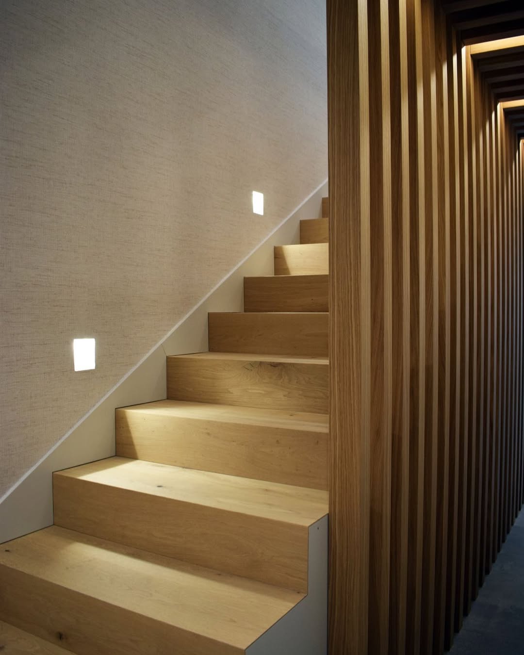Escalera roble natural · Luces empotradas en peldaños · Lamas verticales